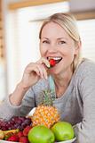Close up of smiling woman having a strawberry