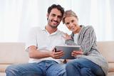 Charming couple using a tablet computer