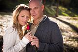 Attractive Young Couple Wearing Sweaters with a Rose in the Park.