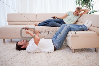 Woman watching television while her boyfriend is using his cellphone