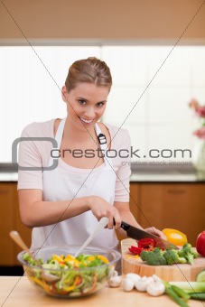 Portrait of a young woman slicing vegetables
