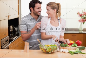 Young couple slicing vegetables