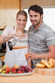 Portrait of a smiling couple drinking fruits juice