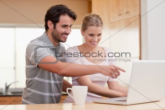 Couple using a notebook while having coffee