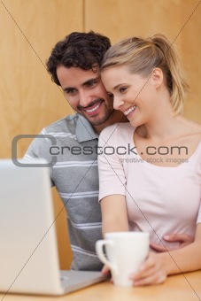 Portrait of a couple using a laptop while having tea