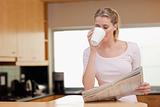 Woman reading the news while having coffee