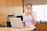Woman using a notebook while drinking orange juice