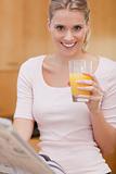 Portrait of a cute woman reading the news while drinking juice