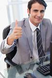 Portrait of a businessman working with a computer with the thumb up