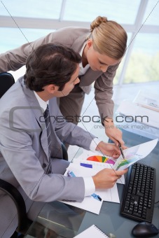 Portrait of a manager pointing at something to her employee on a graph