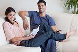 Woman reading a book while her husband is watching TV