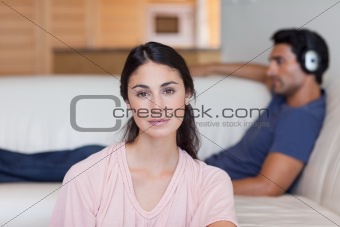 Woman posing while her boyfriend is listening to music