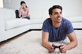 Man playing video games while his girlfriend is getting mad at him
