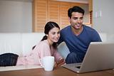 Young couple using a laptop while having a coffee