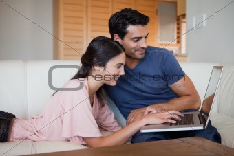 Smiling young couple using a laptop