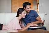 Charming young couple using a laptop