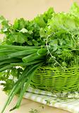 fresh green grass parsley dill onion herbs mix in a wicker basket