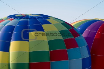 Top sections of hot-air balloons inflating or ascending