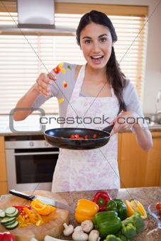 Portrait of a happy woman preparing a dish