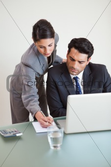 Portrait of a good looking business team working with a laptop