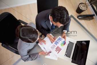 Young sales persons studying statistics