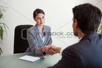 Young manager shaking the hand of a customer