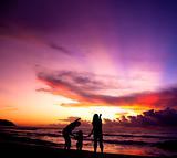 The silhouette of  family watching the sunrise on the beach