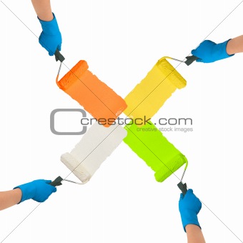 Hands with rollers dipped in bright colors paint each other trac