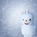 Funny Snowman with carot and sticks under snowy background