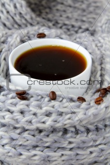 coffee in white cup wrapped in a gray scarf