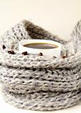 coffee in white cup wrapped in a gray scarf