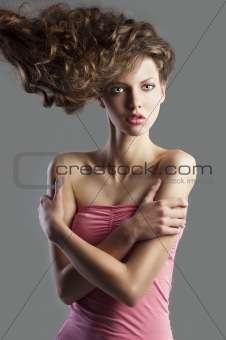 pretty girl with great hair style, her arms are crossed. 