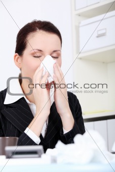 Businesswoman blowing her nose.