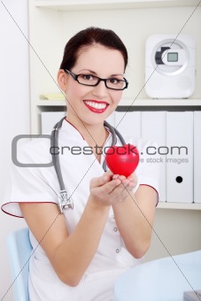 Female doctor holding heart.