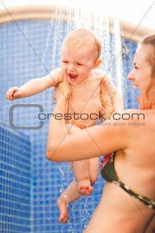Young mother and happy baby taking shower
