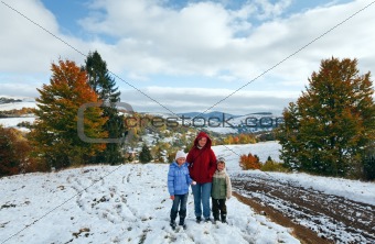 First winter snow in autumn mountain and family on walk
