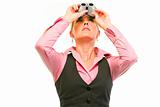 Modern business woman looking up through binoculars
