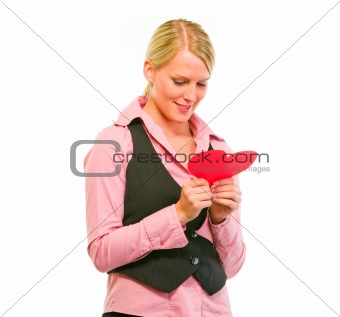 Happy female business secretary reading Valentine paper heart
