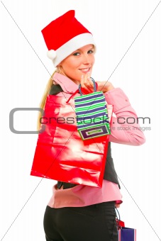 Smiling female business clerk in Santa Hat with shopping bags

