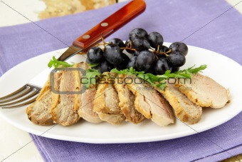 cooked meat duck with berry sauce and salad on a plate