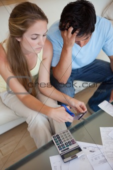 Portrait of a couple cutting their credit card