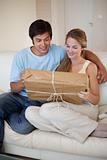 Portrait of a young couple looking at a package