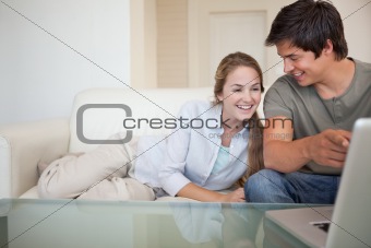 Laughing couple using a notebook