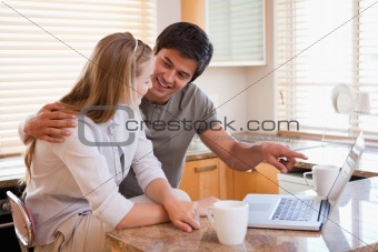 Couple having tea while using a laptop