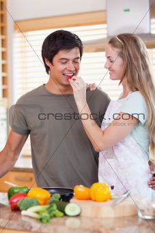 Portrait of a woman making her fiance tasting her meal