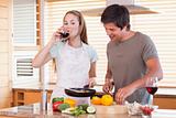 Couple cooking dinner while drinking wine