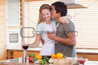 Lovely couple drinking red wine while kissing