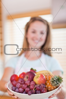 Portrait of a young woman presenting a fruit basket