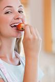 Close up of a woman eating a strawberry