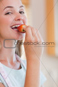 Close up of a woman eating a strawberry